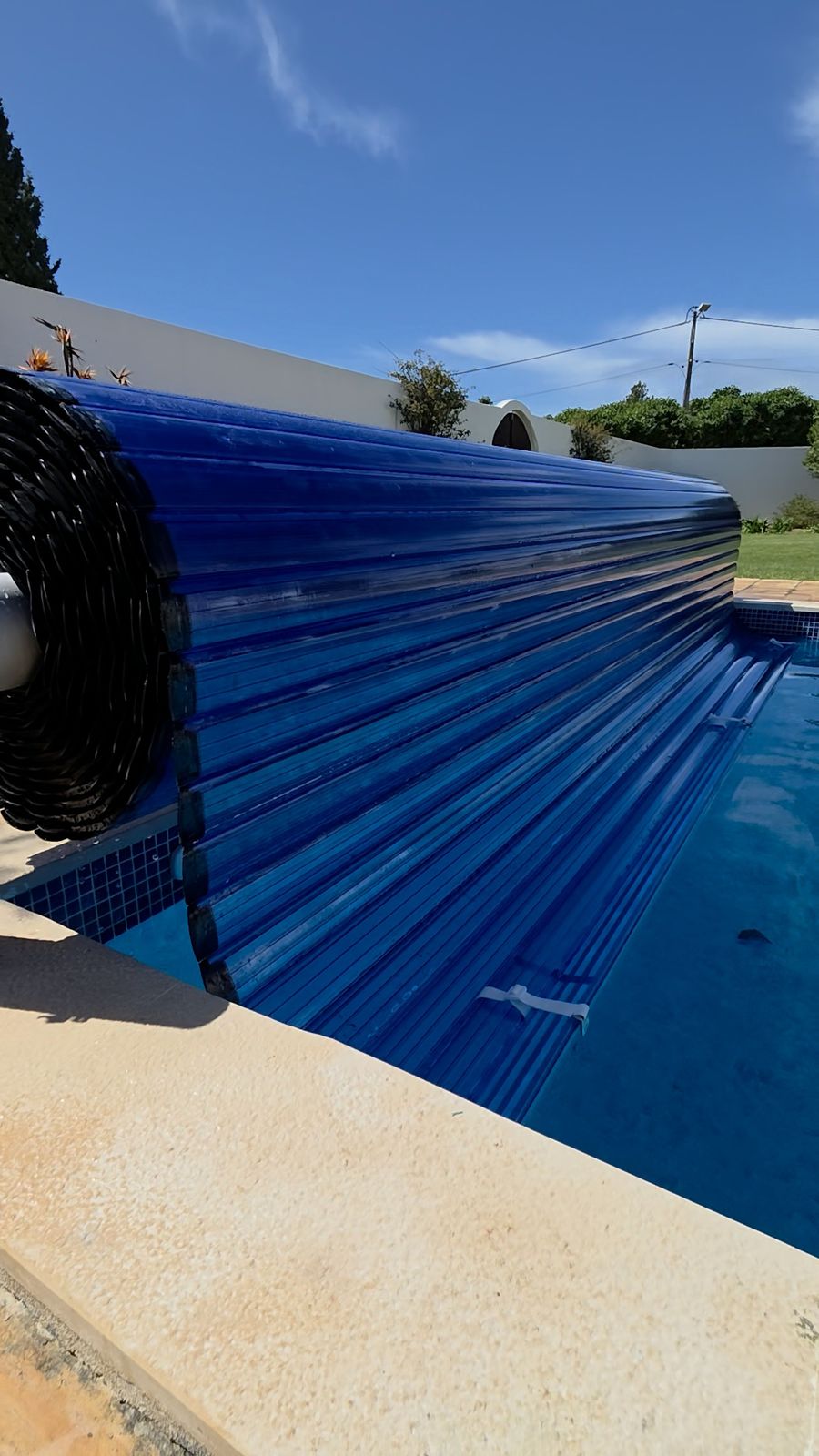 Rolo da cobertura de lâminas sobre a piscina, trabalho concluído
